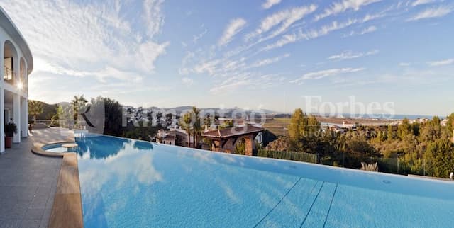 Villa spacieuse au design unique avec des vues sur la vallée et la mer avec une piscine à débordement, un spa et des jardins bien entretenus.